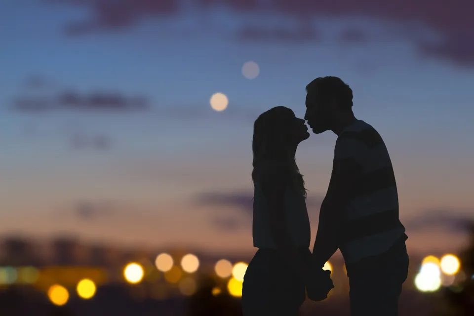 Silhouette couple kissing at sunset