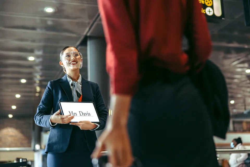 Airport greeter with a sign